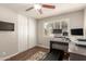 Bedroom featuring home office, ceiling fan, shuttered window and wood floors at 1506 E Gemini Dr, Tempe, AZ 85283