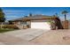 Spacious concrete driveway leading to a two-car garage, complemented by low-maintenance desert landscaping and a clear blue sky at 1506 E Gemini Dr, Tempe, AZ 85283