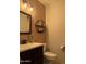 Charming half-bathroom with wood accent wall, stylish mirror, and decorative shelving at 15266 N 146Th Ln, Surprise, AZ 85379