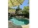 Lush backyard oasis featuring a beautiful pool with sun umbrellas and a stone accent at 15266 N 146Th Ln, Surprise, AZ 85379