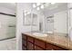 Spacious bathroom highlighting a large mirror, dark cabinets, and shower with glass doors at 15618 N 12Th Ave, Phoenix, AZ 85023