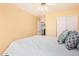 Relaxing bedroom showcasing yellow walls, white closet doors, and doorway to another room at 15618 N 12Th Ave, Phoenix, AZ 85023