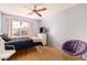 This bedroom features a ceiling fan and a large window allowing natural light and a comfortable seating area at 15618 N 12Th Ave, Phoenix, AZ 85023