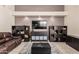 Living room featuring a leather sofa, tile floors, and a large TV at 15618 N 12Th Ave, Phoenix, AZ 85023