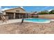 Beautiful pool surrounded by desert landscaping, safety fence, and a covered patio at 15618 N 12Th Ave, Phoenix, AZ 85023