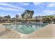 Community pool featuring lounge chairs and sun shade, with neighborhood homes in the background on a clear, sunny day at 1600 N Saba St # 224, Chandler, AZ 85225