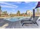 Exterior view of community pool with lounge chairs and neighborhood homes in the background under a blue sky at 1600 N Saba St # 224, Chandler, AZ 85225