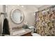 Well-lit bathroom features granite countertop, updated mirror and a decorative cactus shower curtain at 16207 W Moreland St, Goodyear, AZ 85338