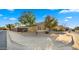 Single story home featuring desert landscaping, mature trees, and a well-maintained yard at 16207 W Moreland St, Goodyear, AZ 85338