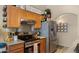 Kitchen with stainless steel refrigerator, granite countertops, and wood cabinetry at 16207 W Moreland St, Goodyear, AZ 85338