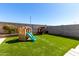 Lush backyard featuring desert landscaping, synthetic grass, playhouse, and a slide at 17445 N 185Th Dr, Surprise, AZ 85374