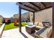 Outdoor patio under a pergola with built-in seating, a fire pit, and a view of the backyard at 17445 N 185Th Dr, Surprise, AZ 85374