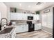 Well-lit kitchen with white cabinetry, black appliances, stylish backsplash, and modern fixtures at 17445 N 185Th Dr, Surprise, AZ 85374