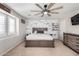 Light-filled main bedroom boasting a wooden accent wall, ceiling fan, and neutral color palette at 17445 N 185Th Dr, Surprise, AZ 85374