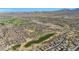 Stunning aerial view of the golf community featuring manicured golf courses, mountain views, and neighborhood streets at 18059 W Ocotillo Ave, Goodyear, AZ 85338