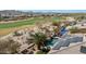 Aerial view of a home with a pool, solar panels, and golf course views, showcasing outdoor living at 18059 W Ocotillo Ave, Goodyear, AZ 85338