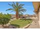 Well-manicured backyard with artificial turf, mature palm trees, and a stunning pool with rock waterfall feature at 18059 W Ocotillo Ave, Goodyear, AZ 85338