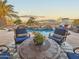 Outdoor seating area showcases a stunning pool with rock waterfall features and an outdoor fireplace at 18059 W Ocotillo Ave, Goodyear, AZ 85338