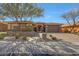 Charming single-story home with stone accents, a well-manicured front yard and mature trees at 18059 W Ocotillo Ave, Goodyear, AZ 85338