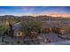 Charming home at dusk with stone accents, desert landscaping, and a picturesque mountain backdrop at 18059 W Ocotillo Ave, Goodyear, AZ 85338