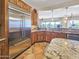 Well lit kitchen featuring wood cabinets, granite countertops, and stainless steel refrigerator at 18059 W Ocotillo Ave, Goodyear, AZ 85338