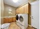 Laundry room with front load washer and dryer, upper cabinets, and a utility sink at 18059 W Ocotillo Ave, Goodyear, AZ 85338