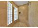 Tiled shower featuring dual shower heads, glass block window and a built-in shower bench at 18059 W Ocotillo Ave, Goodyear, AZ 85338