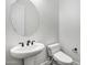 Bathroom featuring a round mirror, toilet, and pedestal sink at 20125 E Melissa Pl, Queen Creek, AZ 85142