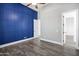 Bright bedroom features a striking blue accent wall, fan and wood-look flooring at 20125 E Melissa Pl, Queen Creek, AZ 85142