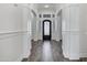 Elegant foyer featuring a decorative iron door, wood-look tile floors, and crisp white walls at 20125 E Melissa Pl, Queen Creek, AZ 85142