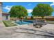 Stunning backyard pool with lush landscaping, a fire pit, and a lounging area for relaxation and outdoor enjoyment at 20125 E Melissa Pl, Queen Creek, AZ 85142