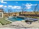 Inviting pool area featuring a modern pool design, cozy fire pit, and lush landscaping, perfect for relaxation and entertainment at 20125 E Melissa Pl, Queen Creek, AZ 85142