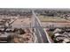 Aerial shot of a wide road cutting through a suburban area with residential homes and open spaces nearby at 2089 E Lynx Pl, Chandler, AZ 85249