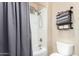 Bathroom featuring a shower/tub with a gray curtain, a white toilet and shelving with gray towels at 2089 E Lynx Pl, Chandler, AZ 85249