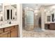 Spa-like bathroom featuring a glass block shower, double vanity, and custom cabinets offering storage at 2089 E Lynx Pl, Chandler, AZ 85249