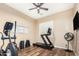 Home gym featuring exercise equipment, a TV, and a ceiling fan in a room with wood floors at 2089 E Lynx Pl, Chandler, AZ 85249