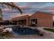 Inviting backyard pool with a fire feature and comfortable lounge seating under a colorful dusk sky at 2089 E Lynx Pl, Chandler, AZ 85249