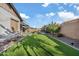 Lush backyard featuring artificial turf, a seating area, and a built-in fireplace at 20981 E Watford Dr, Queen Creek, AZ 85142