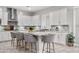Modern kitchen with white cabinetry, stainless steel hood, mosaic backsplash, and a center island with seating at 20981 E Watford Dr, Queen Creek, AZ 85142