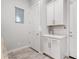 Well-lit laundry room showcasing white cabinetry, a convenient countertop, and tiled floors at 20981 E Watford Dr, Queen Creek, AZ 85142