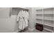 This walk-in closet features ample shelving and two robes hanging on the clothing rail at 21032 N 58Th St, Phoenix, AZ 85054