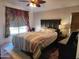 Comfortable bedroom with a ceiling fan, patterned curtains, and a dark wood headboard at 2150 E Bell Rd # 1048, Phoenix, AZ 85022