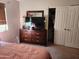 Inviting bedroom with a large dresser, TV, and a mirrored sliding door closet at 2150 E Bell Rd # 1048, Phoenix, AZ 85022