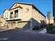 View of a tan home featuring three garages, a balcony, and well-maintained landscaping at 2150 E Bell Rd # 1048, Phoenix, AZ 85022