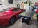 Spacious garage featuring a stylish red car and a recreational ping pong table at 2150 E Bell Rd # 1048, Phoenix, AZ 85022