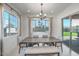 Bright dining room with a large table, bench seating, chandelier, and backyard view at 21757 S 191St Pl, Queen Creek, AZ 85142