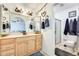 Well-lit bathroom featuring dual mirrors, wooden cabinets, and a separate shower room at 2202 N Los Altos Dr, Chandler, AZ 85224