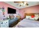 Comfortable bedroom with pink walls, tv, ceiling fan, bed, and other decorations at 2202 N Los Altos Dr, Chandler, AZ 85224