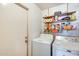 A functional laundry room features a washing machine, a dryer, and storage shelves at 2202 N Los Altos Dr, Chandler, AZ 85224