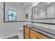 Modern bathroom with a wooden vanity, elegant mirror, and black and white tiling at 2209 N 23Rd St, Phoenix, AZ 85006